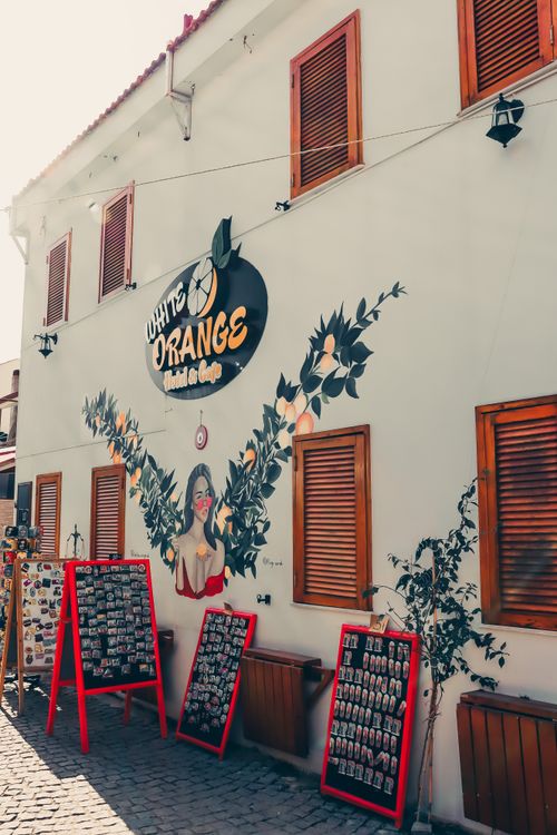 Free Side view of a café with a vibrant mural and retail displays in a lively urban setting. Stock Photo