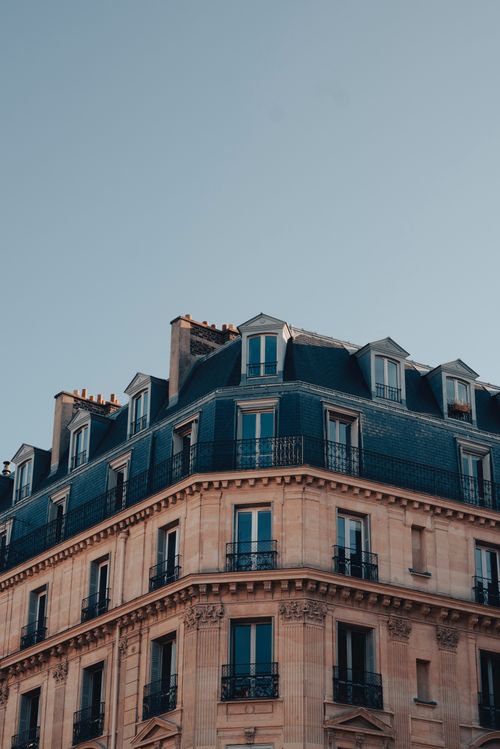 Free Elegant Parisian building facade showcasing classic French architectural style under a clear sky. Stock Photo