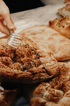 Close-up of freshly baked pita bread being prepared in a bakery setting.