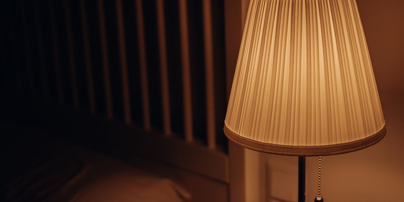 A dimly lit bedside lamp creating a warm and cozy atmosphere in a bedroom setting.