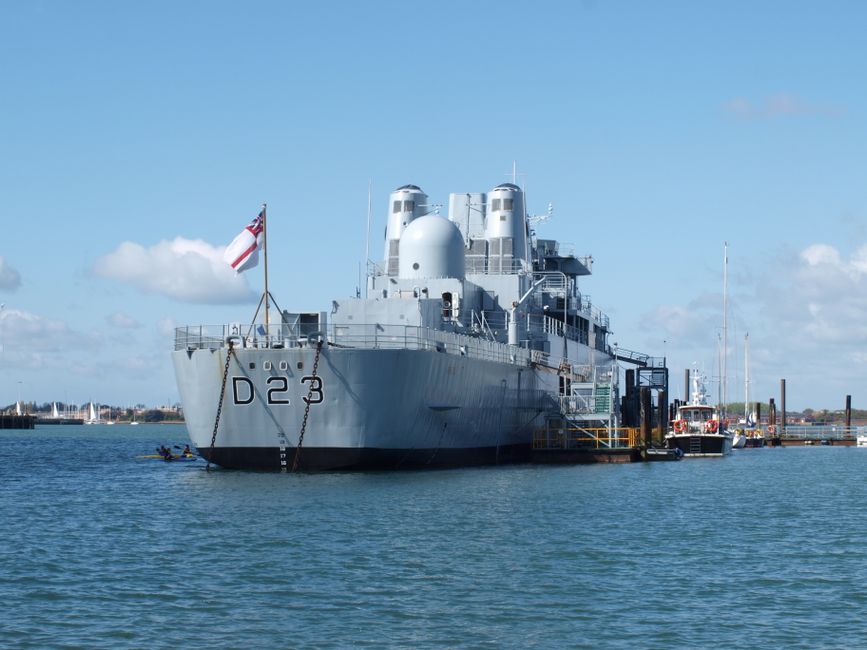 A military warship with D23 insignia docked at Portsmouth, England marina.