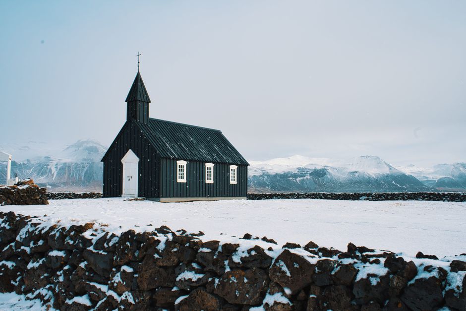 Beautiful view of the iconic black church at Búðir, Iceland, surrounded by a snowy winter landscape.