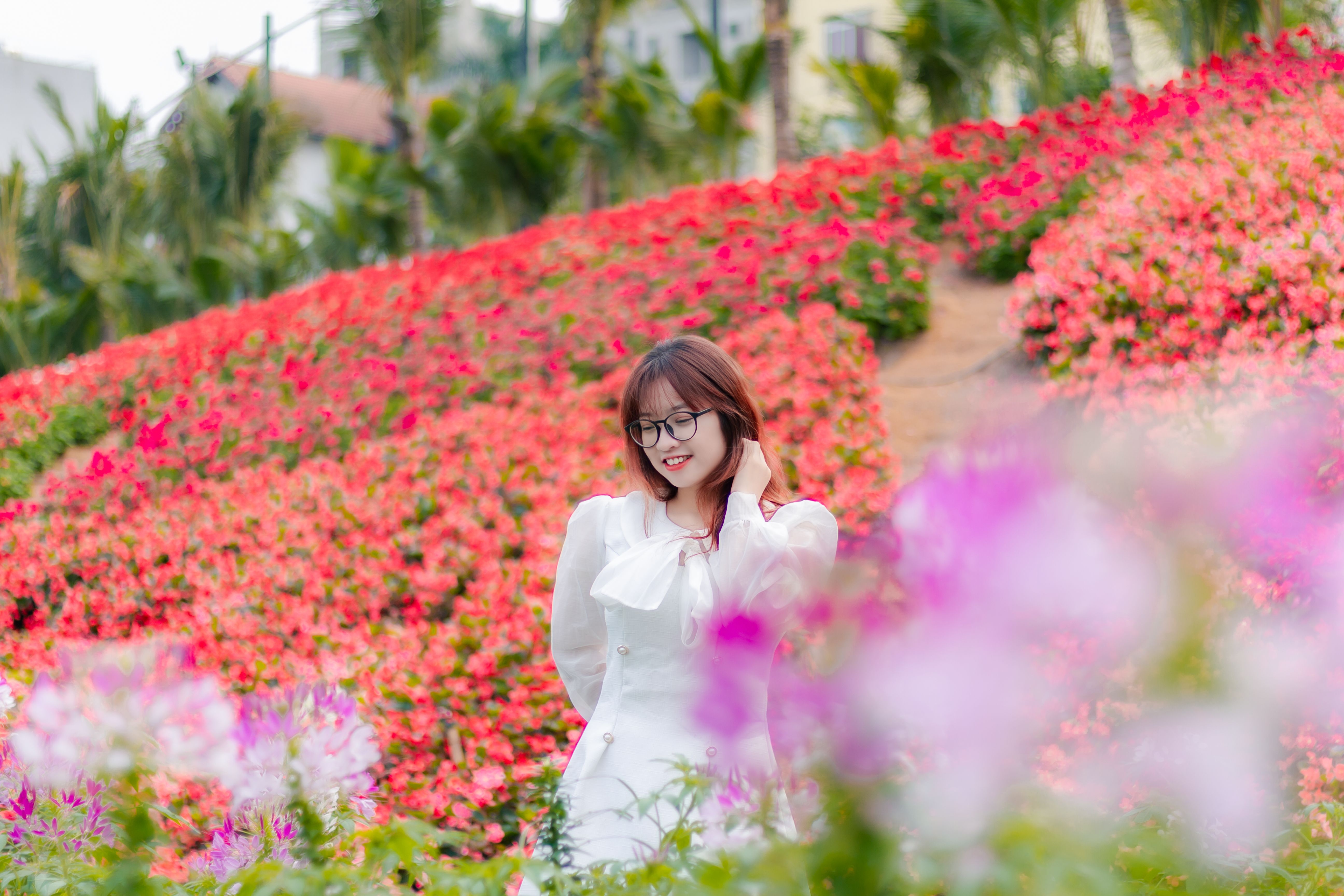 Smiling Woman Posing among Flowers · Free Stock Photo