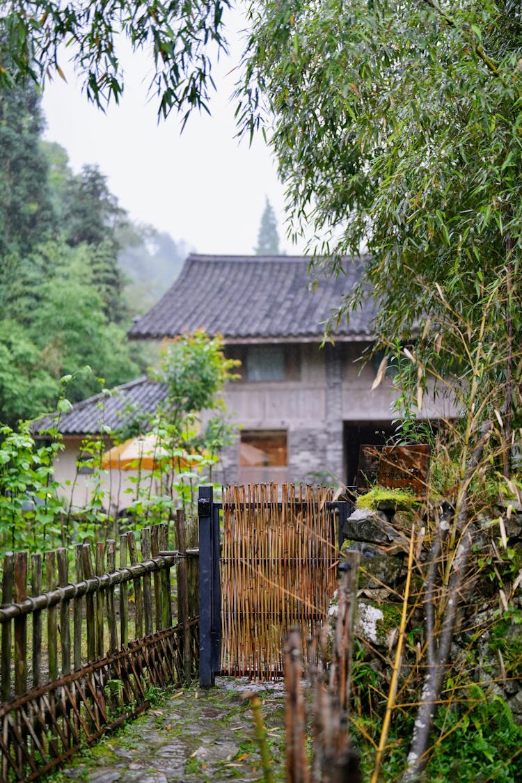 A Fence And A Gate To A Garden By A House In A Village 