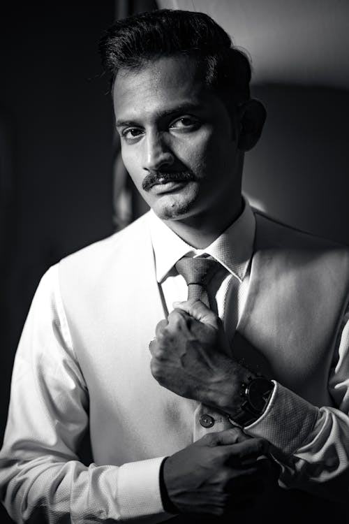 Black and White Shot of a Man Fixing his Cuffs