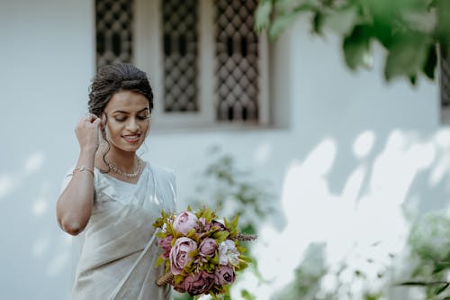Bride Holding a Bouquet and Standing Outdoors 