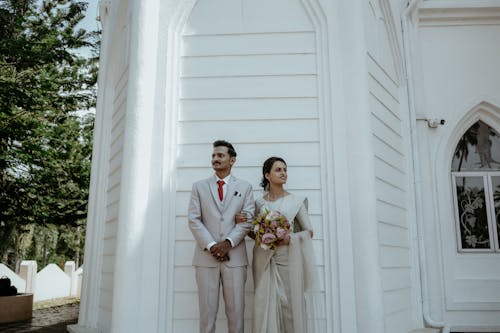 Newlyweds Posing Together by Wall