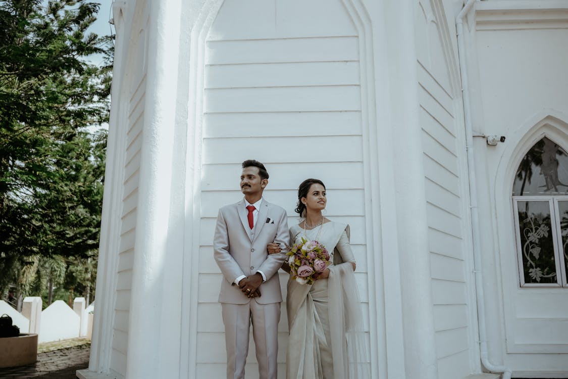 Newlyweds Posing Together by Wall