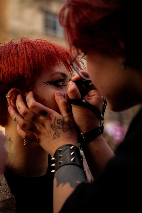 Free A person applying bold eyeliner in an outdoor setting in Ankara, Türkiye, showcasing street fashion. Stock Photo