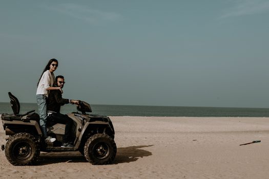 Woman and Man Riding on a Quad on a Beach