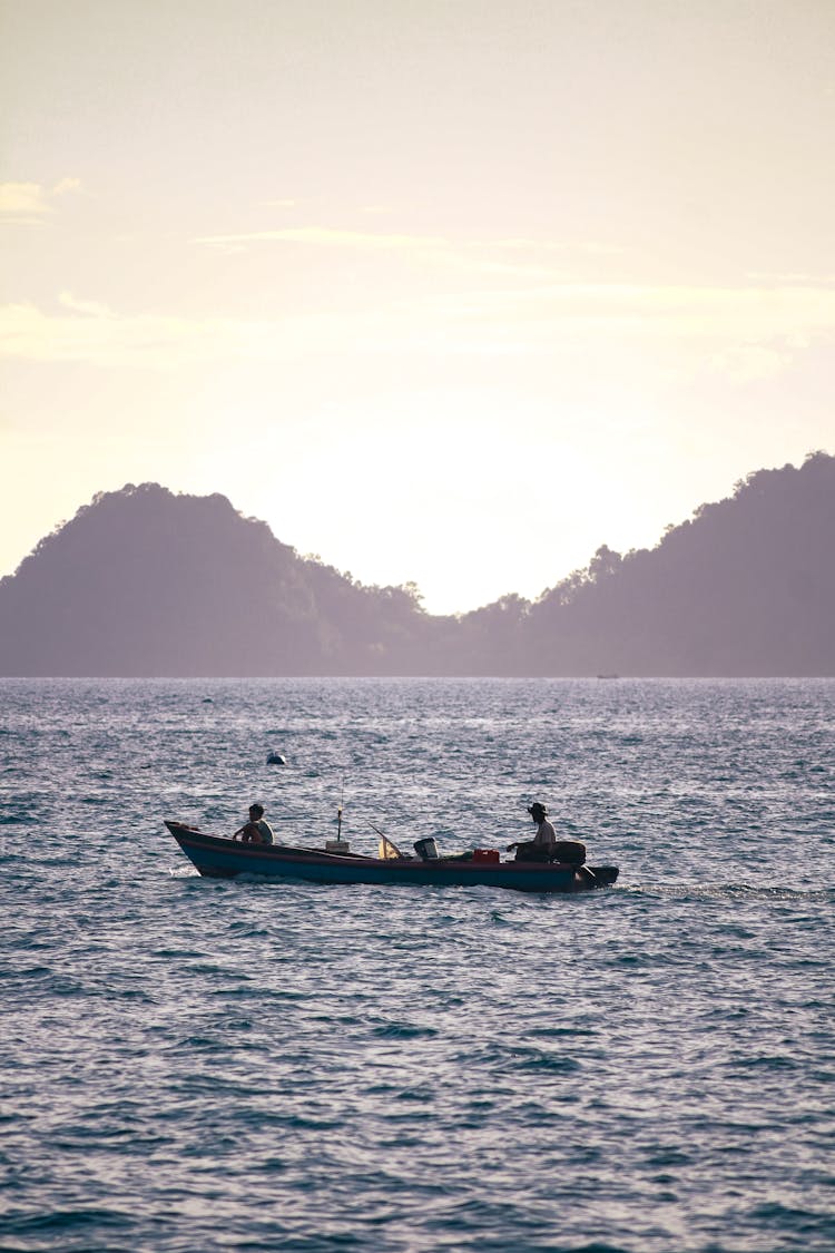 People On Boat On Lake At Sunset