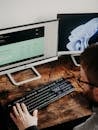 Man Sitting at Desk Working on Computers