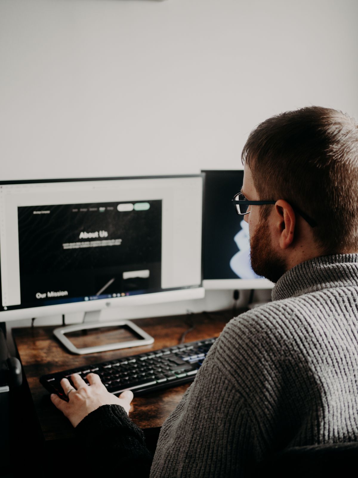 Man Coding on Computers Sitting at Desk · Free Stock Photo