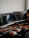 Man Sitting at Desk Working on Computers