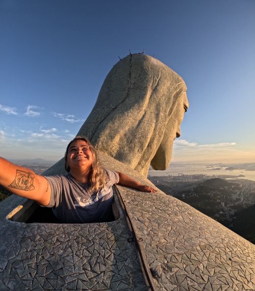 Free A woman joyfully embraces the view from Christ the Redeemer in Rio de Janeiro, Brazil at sunrise. Stock Photo