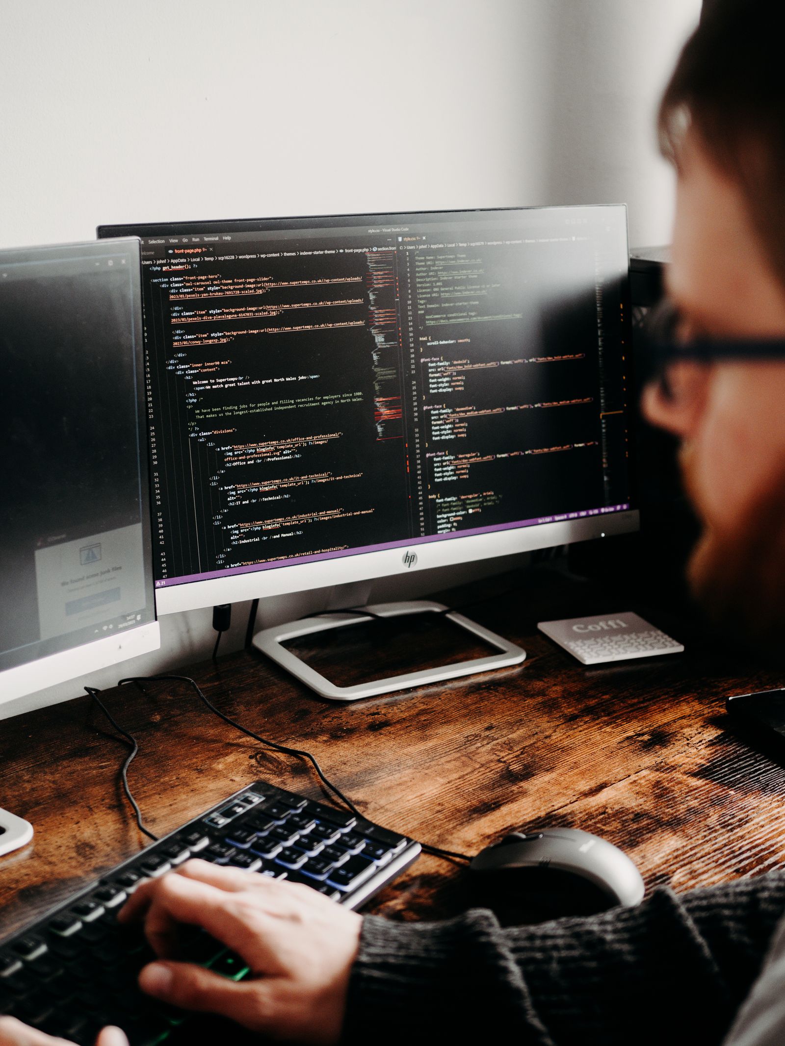 Developer working across multiple monitors, staying current with tools and updates