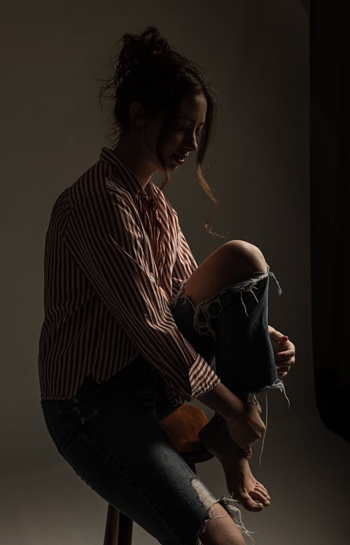 Woman in Ripped Jeans Posing in Studio 