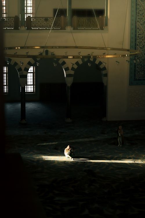 Free A person sits in solitude in a mosque, bathed in sunlight, capturing serene spirituality. Stock Photo