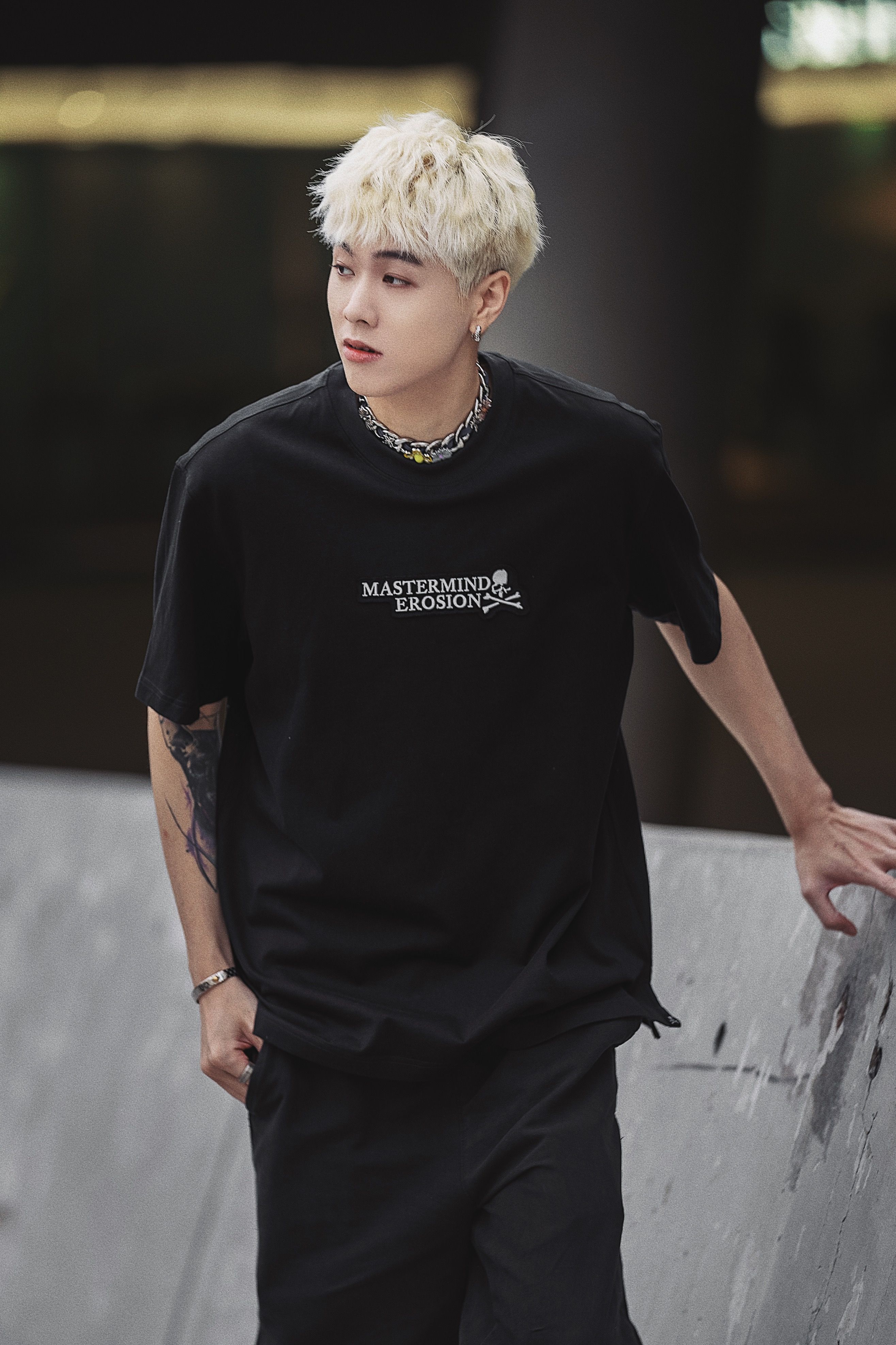 Portrait of a fashionable young man with dyed hair in a black t-shirt, exuding modern style.
