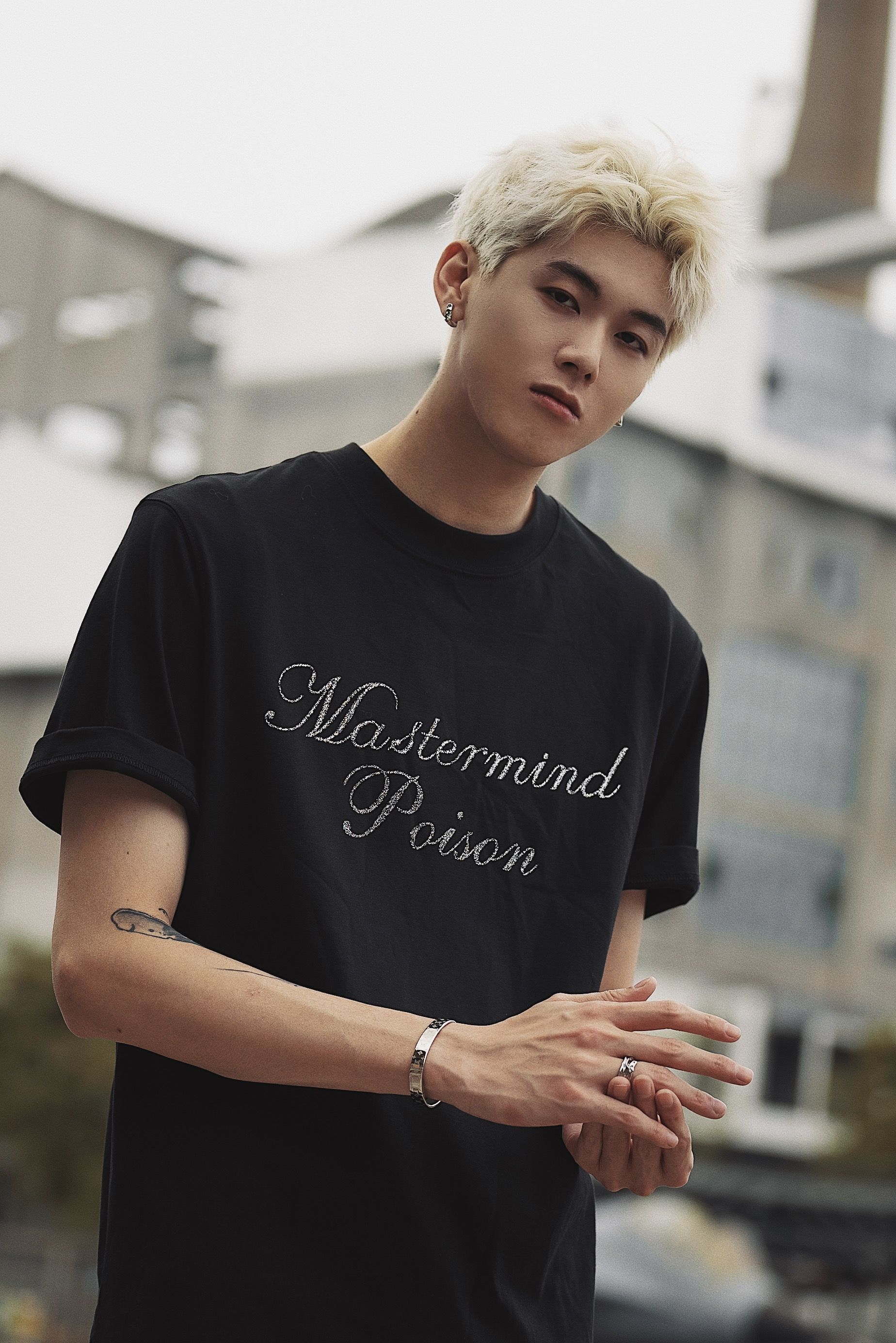 Portrait of a fashionable young man with blonde hair in an urban environment.