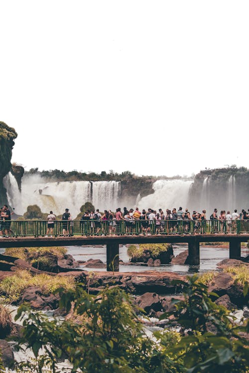 People Walking on a Bridge with View of the Iguazu Falls