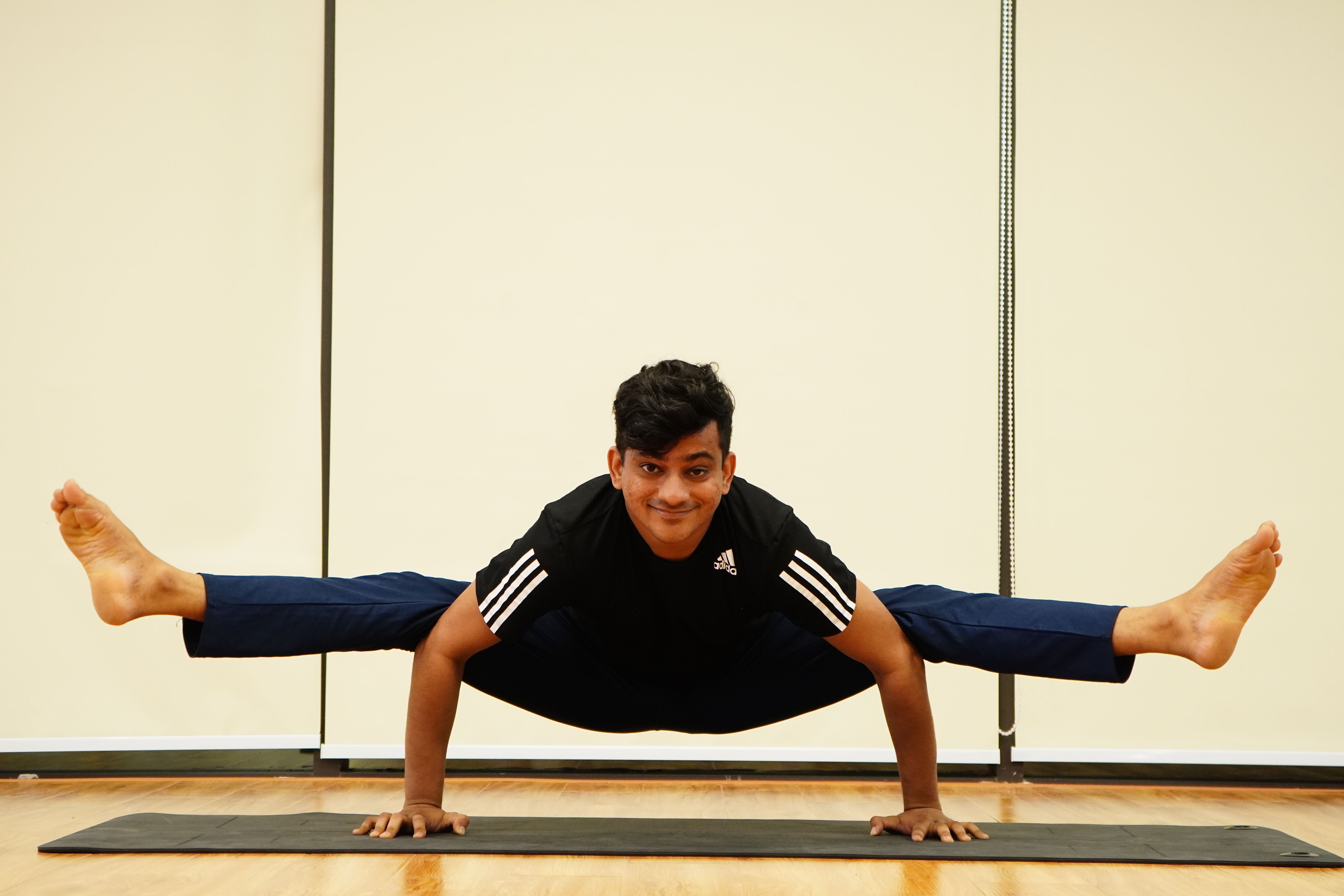 Yoga teacher demonstrating advanced pose on mat