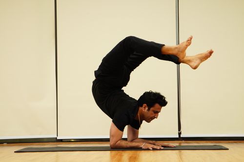 Free A man demonstrates impressive flexibility and skill performing a handstand on a mat indoors, showcasing balance and athleticism. Stock Photo