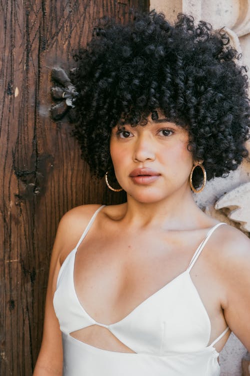 Young Woman with Curly Hair Wearing a White Dress