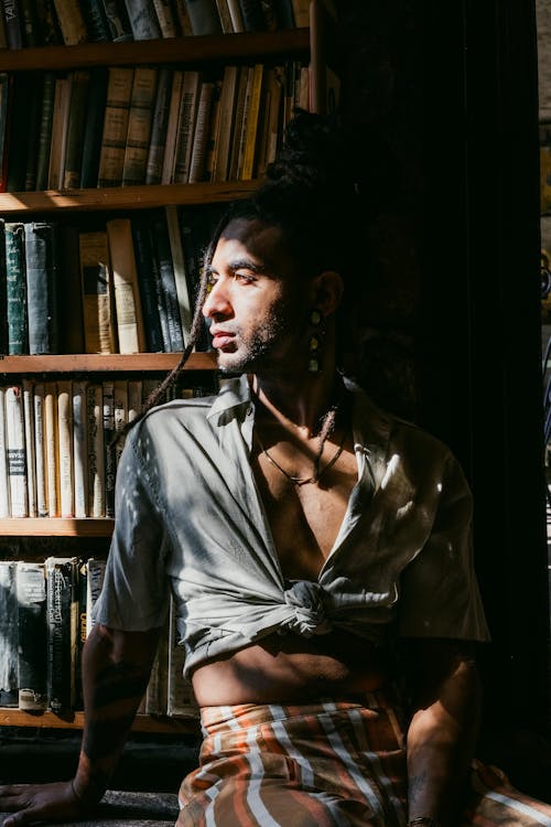 Model with Dreadlocks Posing by Shelves with Books