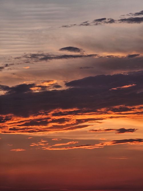 Free A breathtaking orange sunset with dramatic clouds creating a stunning skyscape. Stock Photo