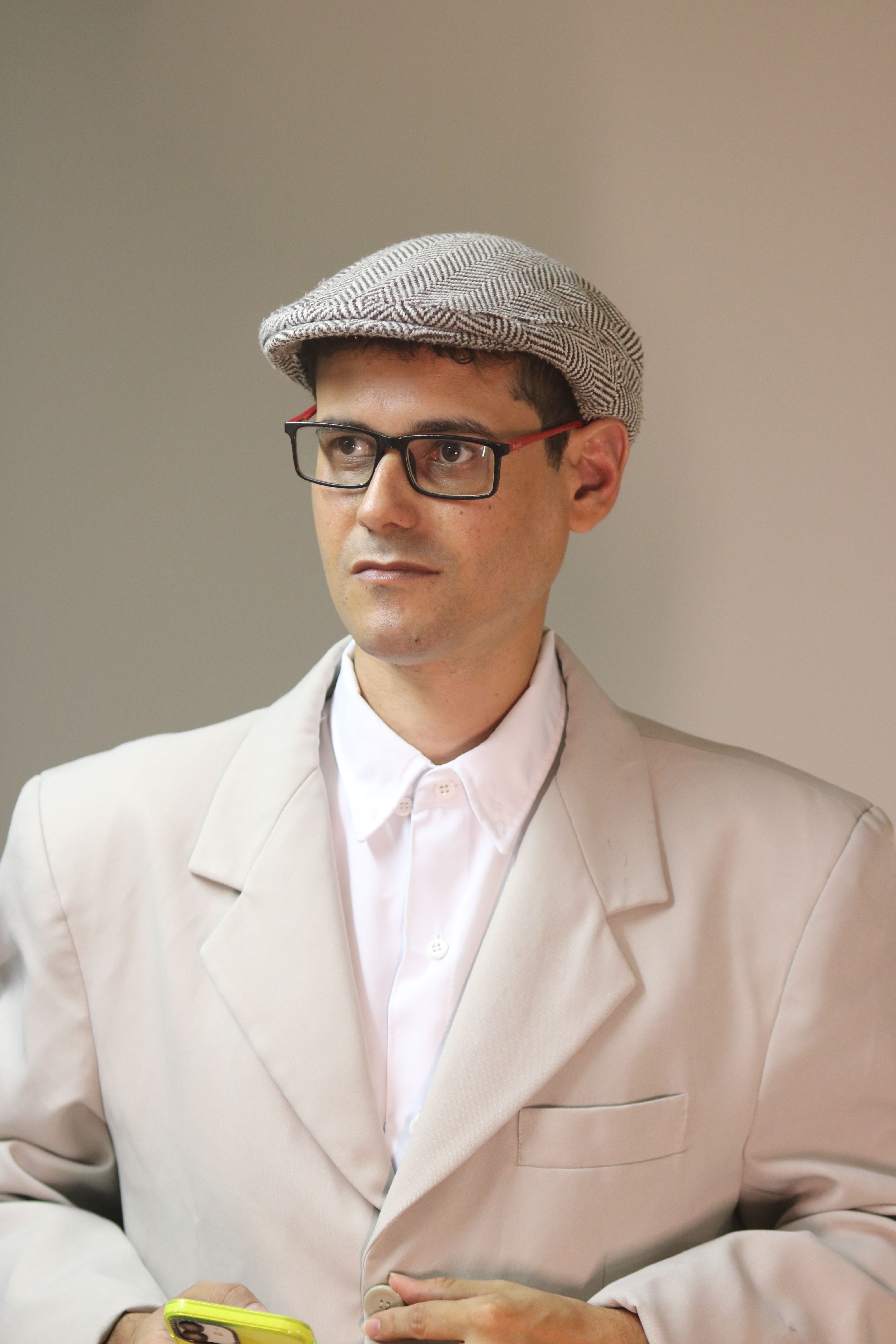 Sophisticated portrait of a man wearing a white suit and flat cap, exuding intelligence.