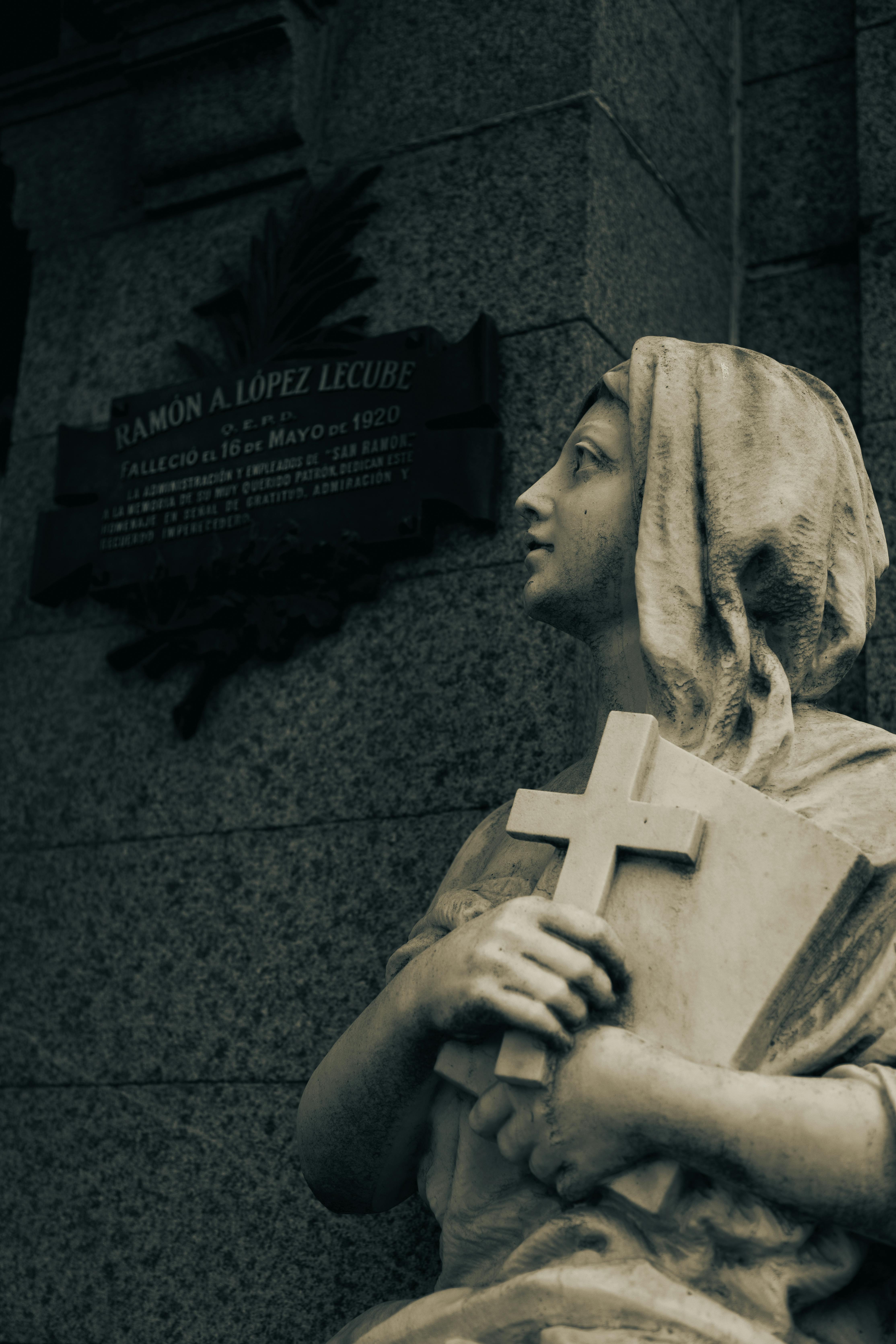 Sculpture of a woman holding a cross in Recoleta Cemetery, Buenos Aires.
