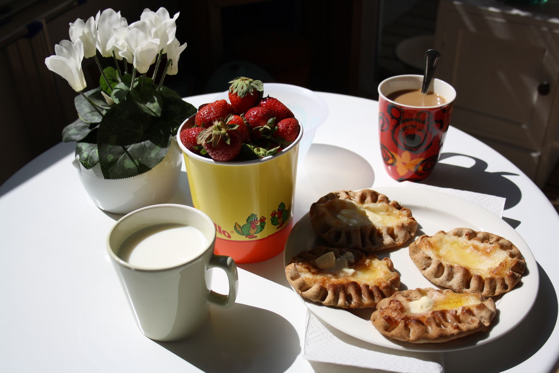 Long breakfast table laid with pastries, fruit and coffee