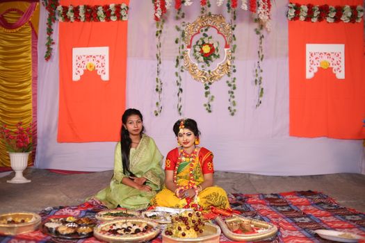 Women Wearing Traditional Clothing Sitting on a Decorative Blanket with Food
