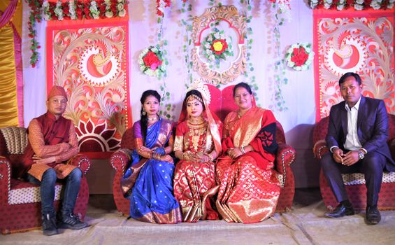 Men and Women Wearing Traditional Clothing Posing against a Decorative Wall