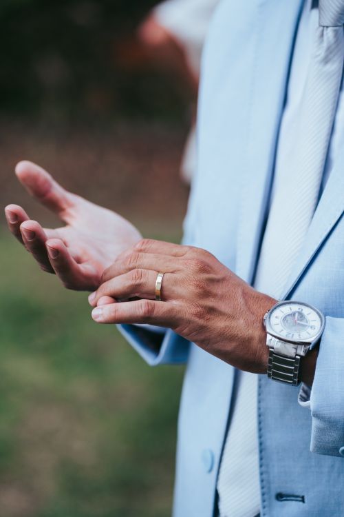 Free Close-up of a man's hands with wristwatch and wedding ring, wearing a suit. Stock Photo