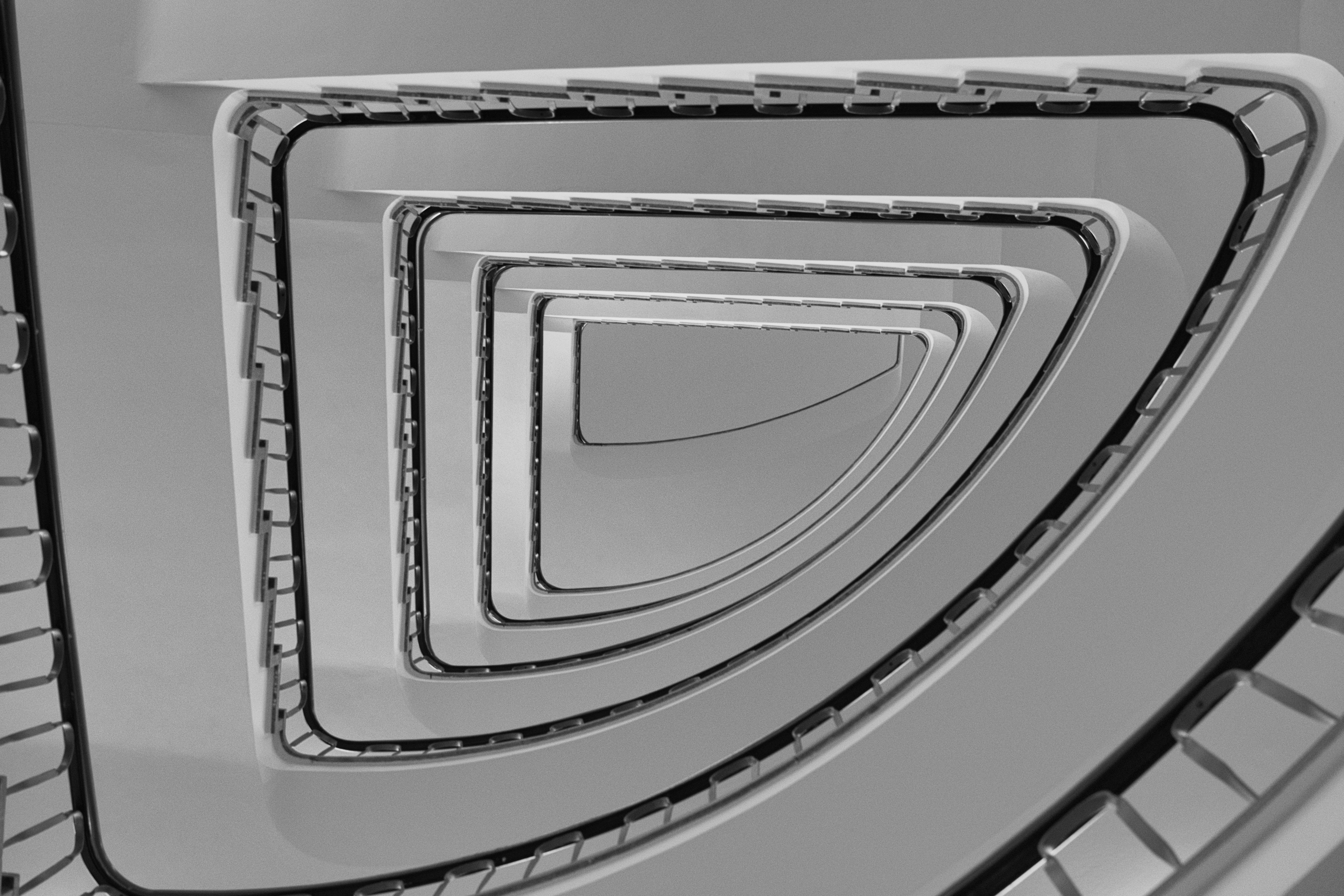 Mesmerizing black and white view of a spiral staircase showcasing modern architectural symmetry.