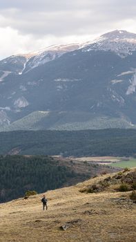 A lone hiker explores a vast mountain range with breathtaking views and serene solitude.