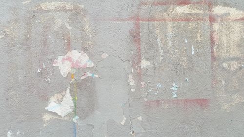 Free Close-up of a textured gray wall showing decay and scattered paint stains. Stock Photo