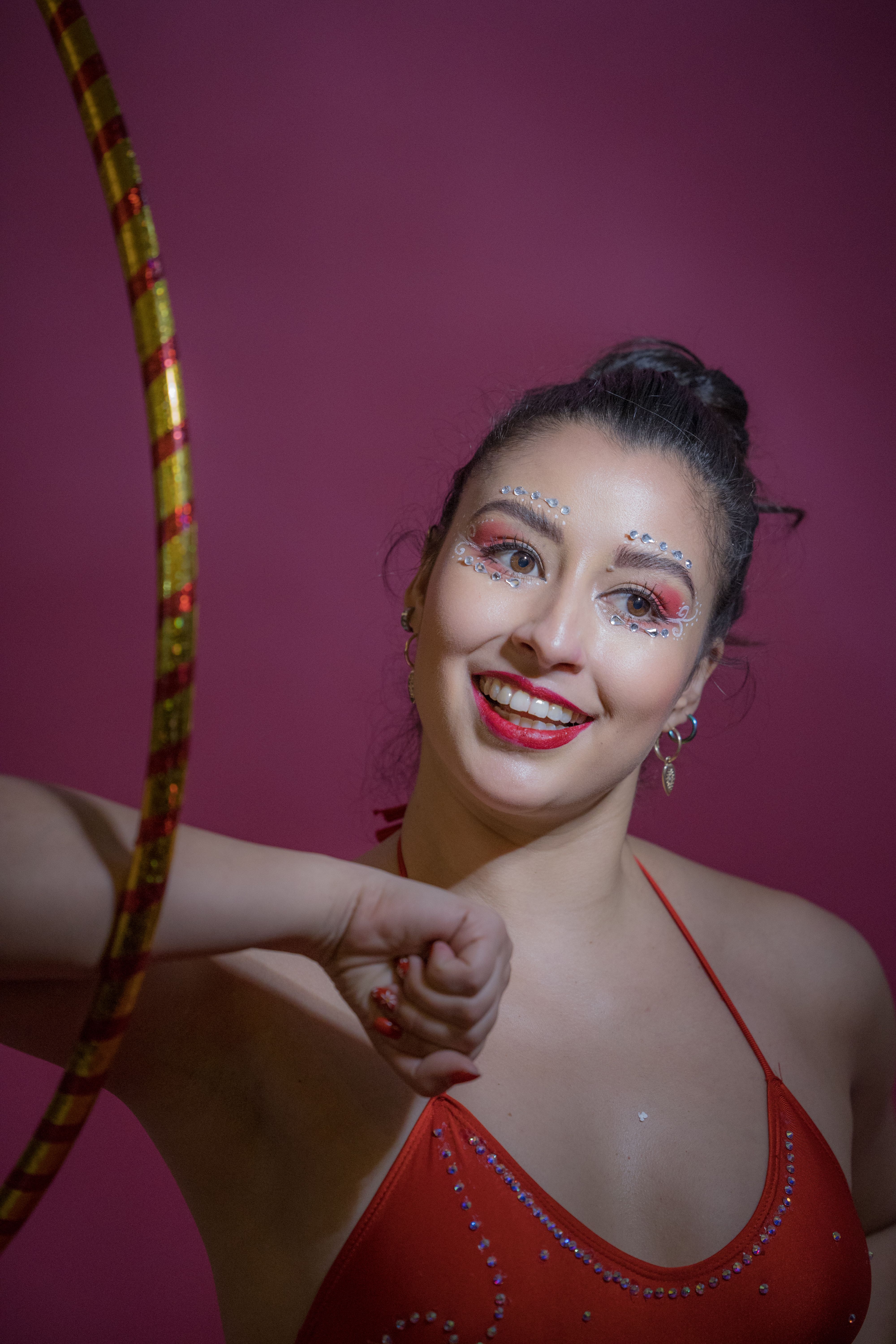 Smiling Woman in Red Bra with Hoop on Elbow · Free Stock Photo