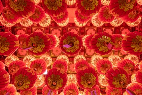 Free Vibrant red lanterns illuminate the ornate ceiling of a traditional Chinese temple. Stock Photo