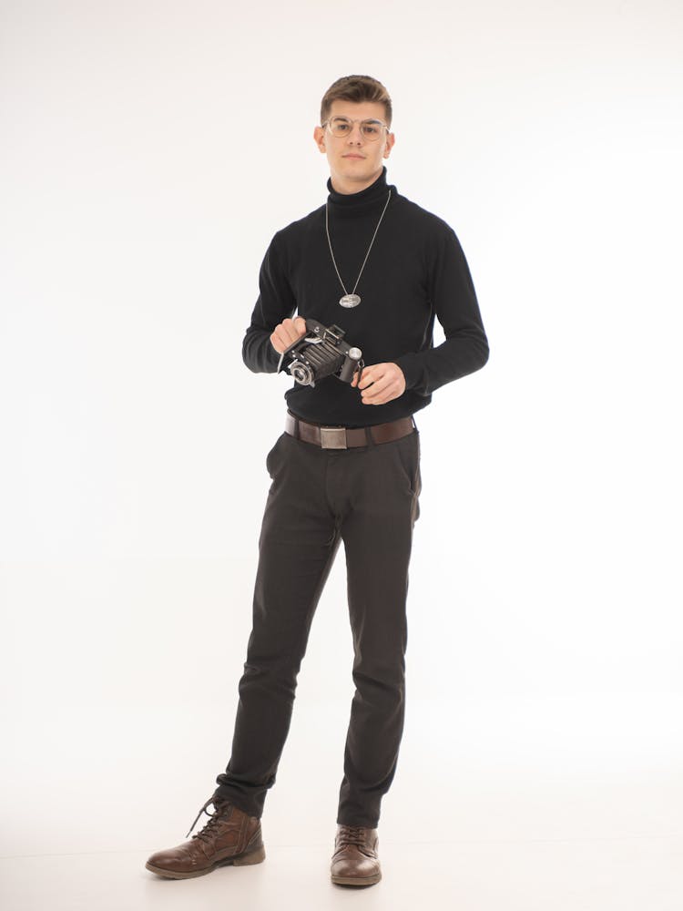 A Man In Black Outfit Holding Camera