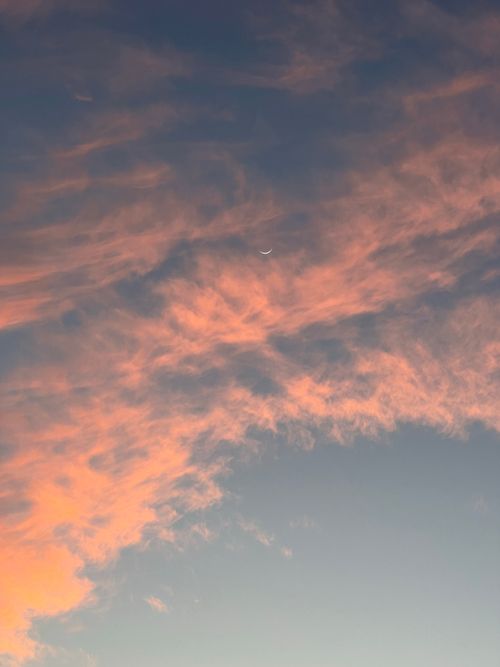 Free A serene sunset sky featuring pink clouds and a delicate crescent moon, perfect for tranquil moods. Stock Photo