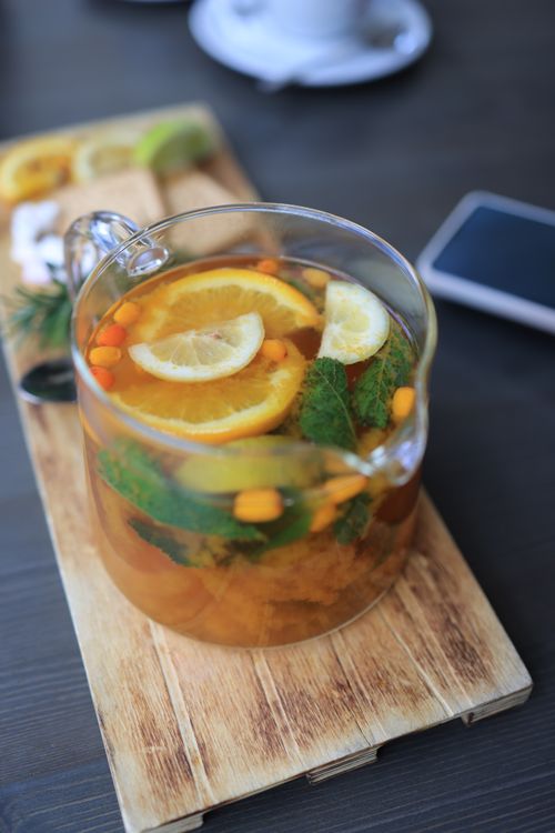 Free Close-up of citrus and mint herbal tea in a clear teapot on a wooden tray, perfect for a cozy day. Stock Photo