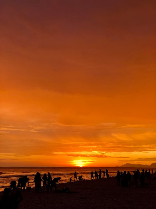 Free Sunset over Beach with People Stock Photo