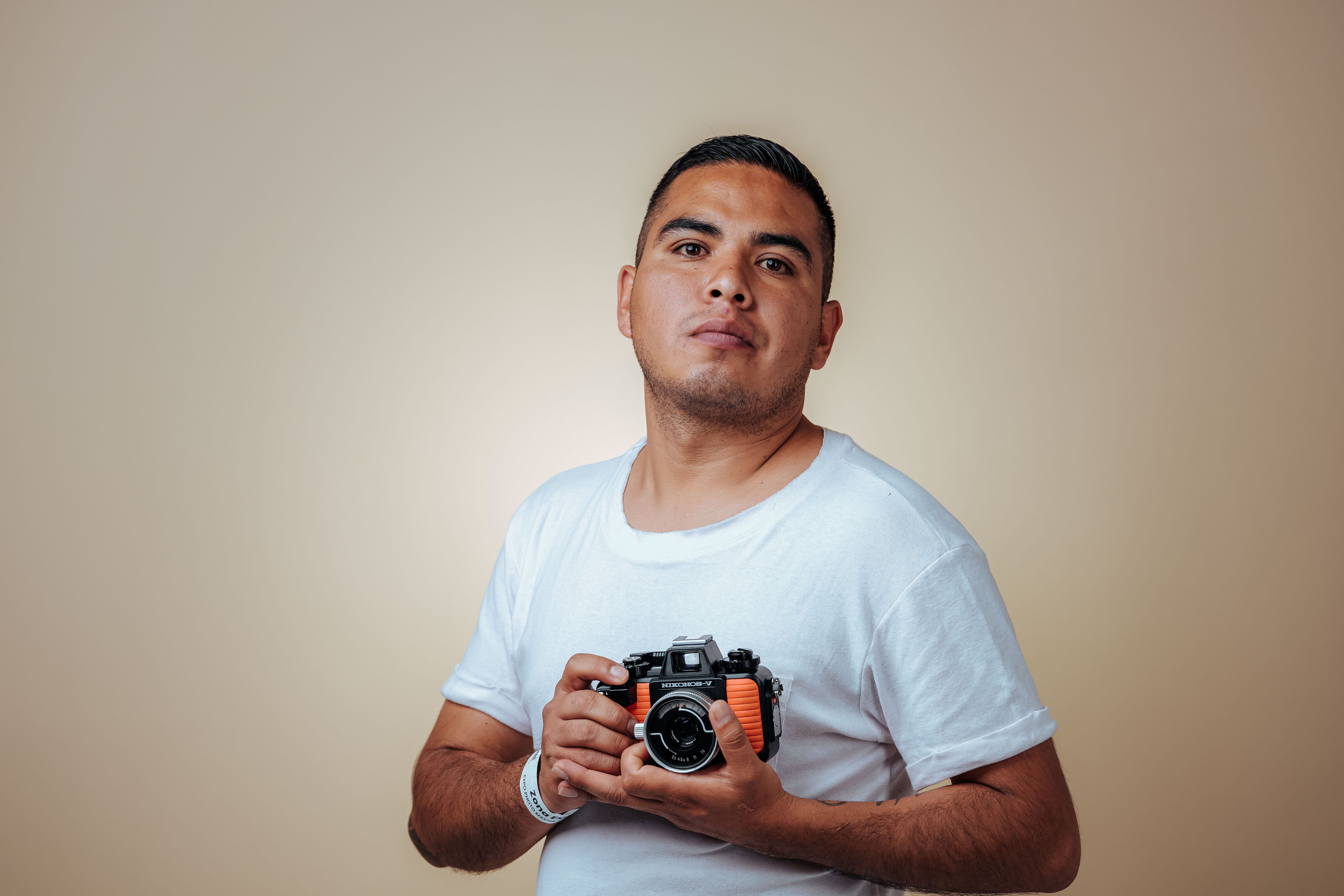 Fotógrafo usando flash para câmera retrô montado no sapato quente durante ensaio