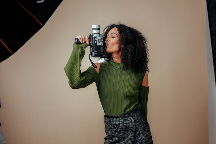 An Attractive Woman Kissing A Vintage Camera