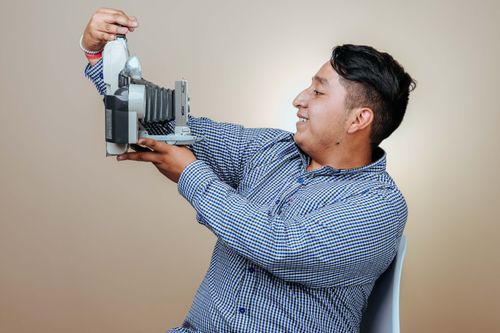 Free Portrait of a man holding a vintage camera in a studio setting. Stock Photo