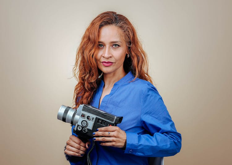 Woman In A Shirt Holding A Camera In A Studio Shoot