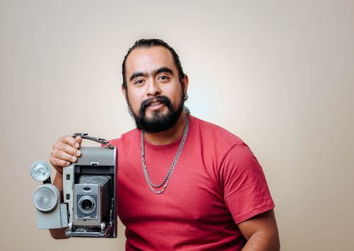 Free Studio portrait of a bearded man with vintage camera, showcasing retro style. Stock Photo